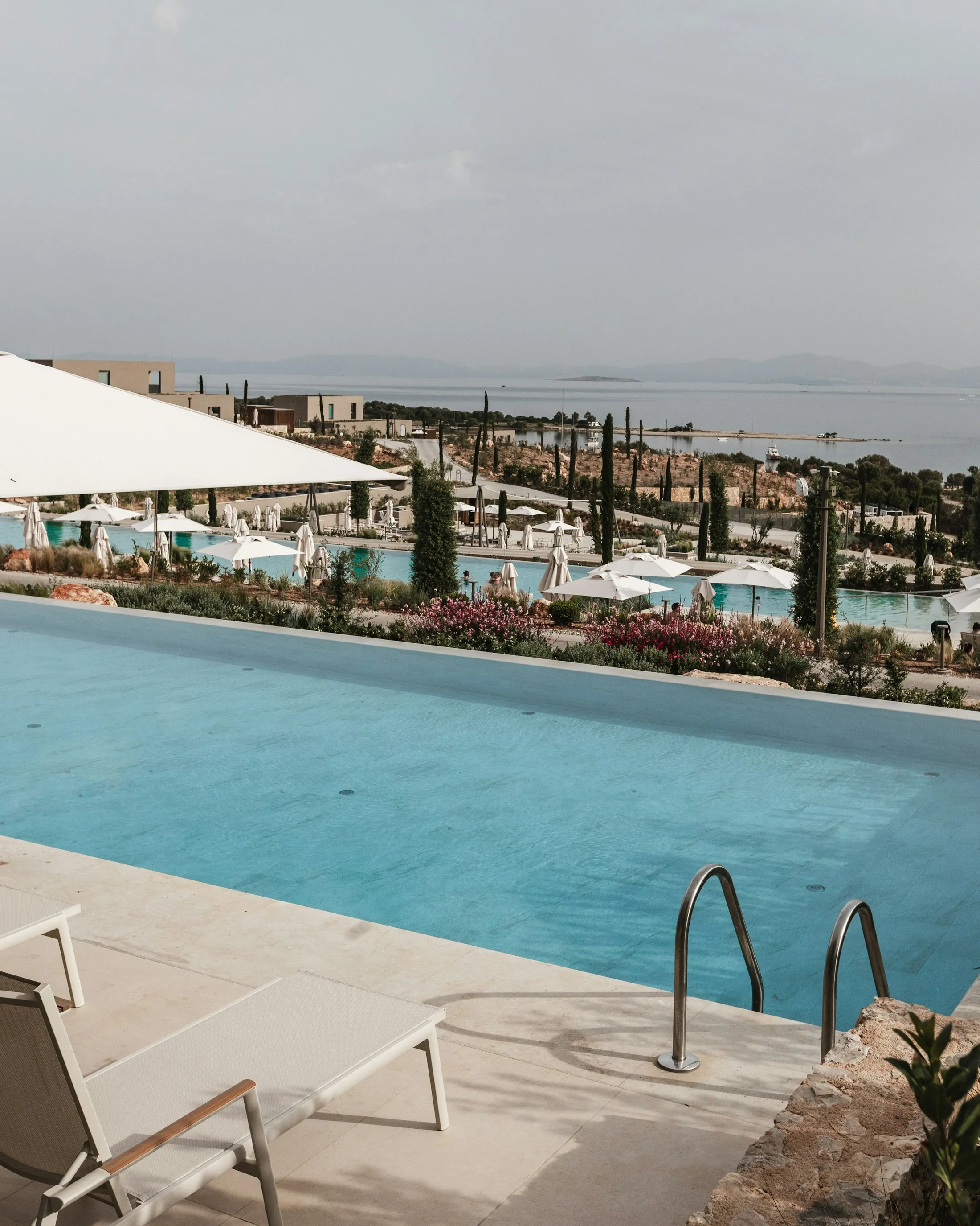 Infinity pool and lounge chairs at a luxury resort overlooking the ocean
