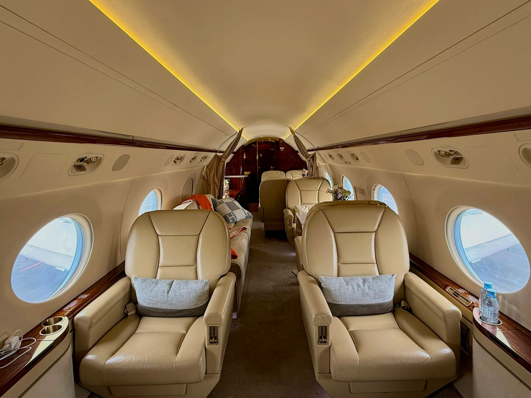 Luxurious private jet cabin with comfortable green seats and warm lighting